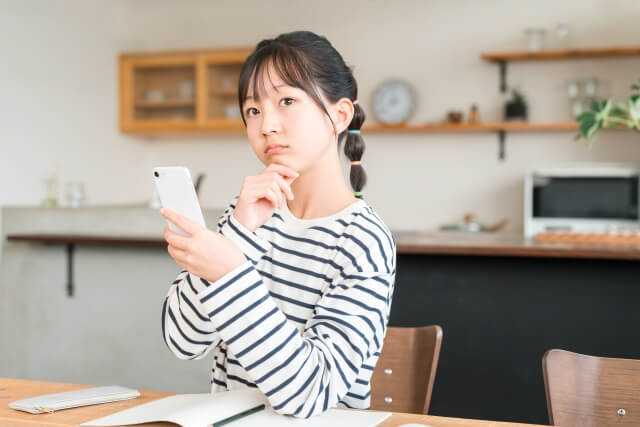 スマホで情報を調べる女性の姿